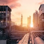 Pipeline and pipe rack of industrial plant with sunset sky backg