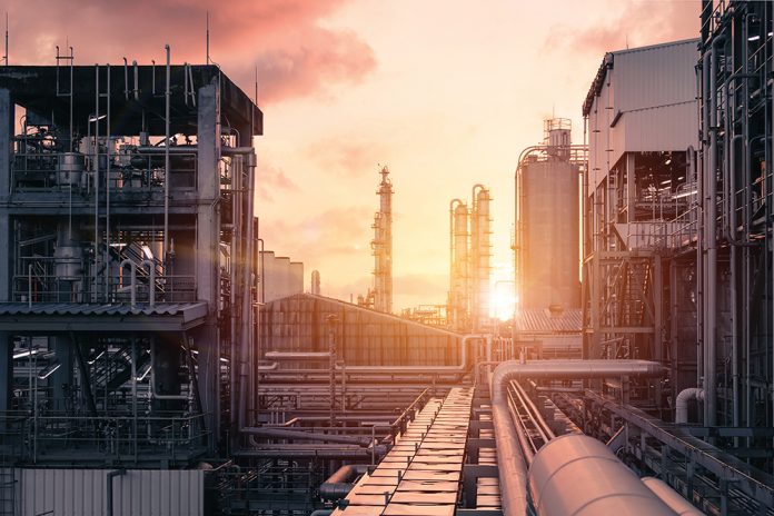 Pipeline and pipe rack of industrial plant with sunset sky backg