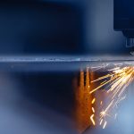 Blue color Laser CNC cut of metal with light spark, technology modern industrial