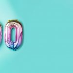 Rainbow foil balloon number, digit one hundred. Birthday greeting card with inscription 100. Anniversary concept. Top view. Colored numeral on blue background. Numerical digit, Celebration event