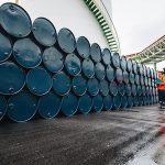 Male worker inspection record drum oil stock barrels blue horizo