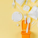 White single use plastic in garbage bin on  yellow background.Concept of Recycling plastic. Flat lay, top view