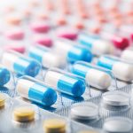 Heap of medical pills in white, blue and other colors. Pills in