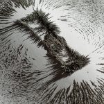 Iron dust showing the magnetic field near a magnet bar on white
